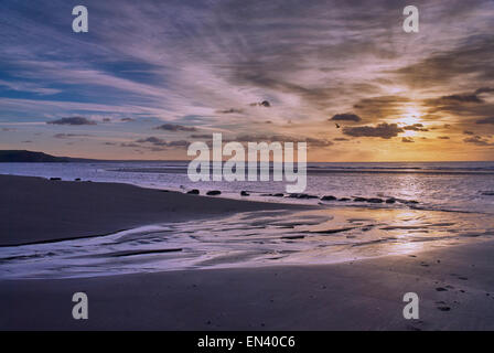 Sonnenuntergang am Strand in Ynyslas, Wales als die Sonne beginnt am Horizont. Stockfoto