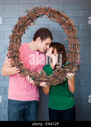 Junge Brautpaar posiert mit geflochtenen Kranz Stockfoto