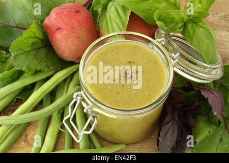 Suppe mit grünen Bohnen in einem Glas mit Zutat in einem Holzbrett Stockfoto