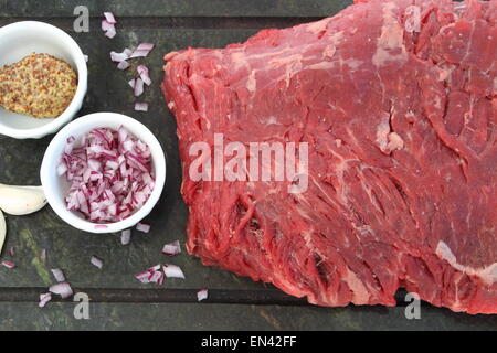 Rohe leer Steak mit Französisch, Schalotte, Senf und Knoblauch auf einem Granit-Hintergrund Stockfoto