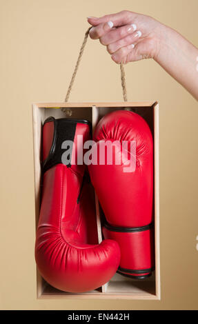 Frau mit ein paar roten Boxhandschuhe in einer Geschenkbox aus Holz Stockfoto