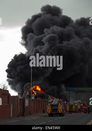 27. April 2015, Salford größere Manchester UK. Feuerwehrleute bekämpfen eine riesige Flamme vor Ort, die Überdachung der alten Unternehmen auf Adelphi St Stockfoto