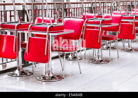 Gestapelte rote Ledersessel in einem geschlossenen Restaurant im Vereinigten Königreich Stockfoto