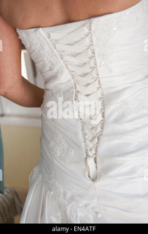 Rückseite einer Bräute Hochzeit Kleid zeigt Nahaufnahme Detail der Korsett-Schnürung Stockfoto