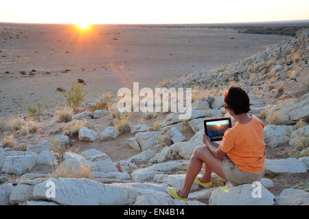 Frau fotografieren Sonnenuntergang mit dem Ipad in der Namib-Wüste, Solitaire, Namib-Wüste, Republik Namibia Stockfoto