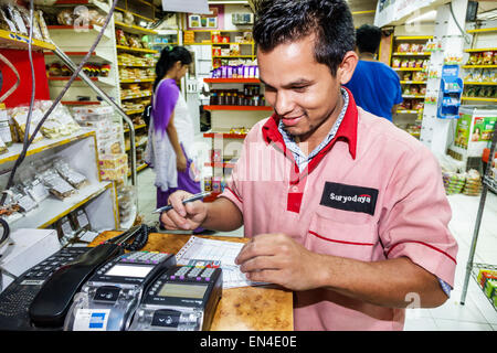 Mumbai Indien, Churchgate, Suryodaya im Inneren Lebensmittelgeschäft Supermarkt Mann, Mitarbeiter Arbeiter arbeiten Kreditkarte Scanner mit Tragen trägt unifor Stockfoto