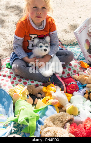 Vrijmarkt Könige Tag in Amsterdam. Kleines Mädchen verkaufen ihre abgelegten Stofftiere, Stofftiere in Amsterdam Vondel Park Stockfoto