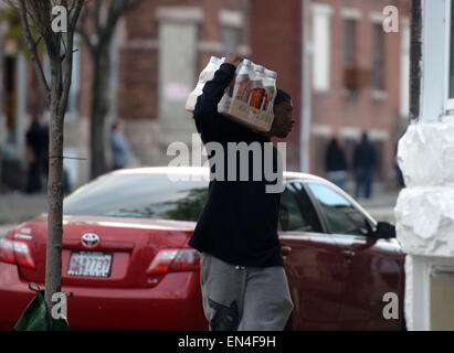 Baltimore, USA. 27. April 2015. Ein Mann trägt Ware aus einem Laden in Baltimore, Maryland, USA, 27. April 2015 geplündert. Gouverneur von Maryland Larry Hogan Montagabend erklärte einen Ausnahmezustand und aktiviert die Nationalgarde Bewältigung der eskalierenden Gewalt und Unruhen in Baltimore Stadt Anschluss an die Beerdigung ein 25-j hrige schwarzer Mann, der starb, nachdem er in Polizeigewahrsam verletzt wurde. Bildnachweis: Yin Bogu/Xinhua/Alamy Live-Nachrichten Stockfoto