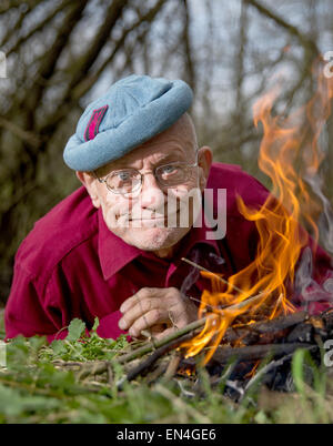 Rausdorf, Deutschland. 21. April 2015. Deutsche überleben Experten und menschliche Rechte Aktivist Ruediger Nehberg zündet ein Feuer auf seinem privaten Grundstück in Rausdorf, Deutschland, 21. April 2015. Nehberg feiert seinen 80. Birdthday am 4. Mai 2015. Foto: Axel Heimken/Dpa/Alamy Live News Stockfoto