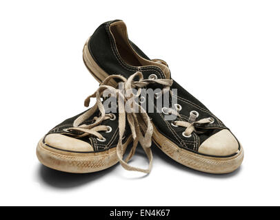 Schmutzige getragene Schuhe auf einander gestapelt isolierten auf weißen Hintergrund. Stockfoto