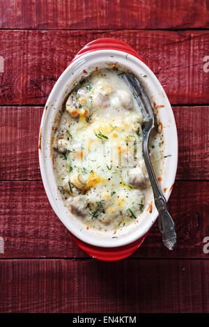 Champignons gebacken in Käsesauce auf den Brettern, Essen Stockfoto