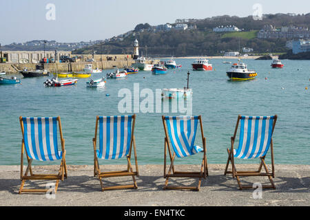 Liegestühle am Meer Hafen in St. Ives, Cornwall, England. Stockfoto