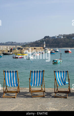 Liegestühle am Meer Hafen in St. Ives, Cornwall, England. Stockfoto