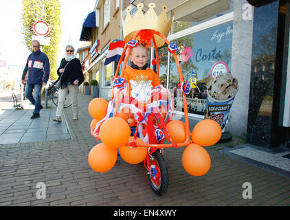 Voorschoten, Niederlande. 27. April 2015. Ein junges Mädchen ist auf einem Fahrrad in Orange, die nationalen Farbe für die Feier der Geburtstag des Königs geschmückt gesehen. Bildnachweis: Jaap Aires/Alamy Live-Nachrichten Stockfoto