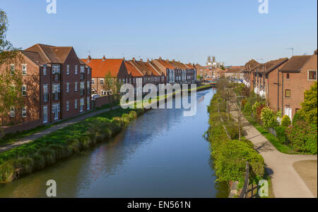 Blick entlang der Beck (Kanal), flankiert von Wohnhäusern mit Münster (Kirche) am Horizont bei Beverley, Yorkshire, Großbritannien. Stockfoto