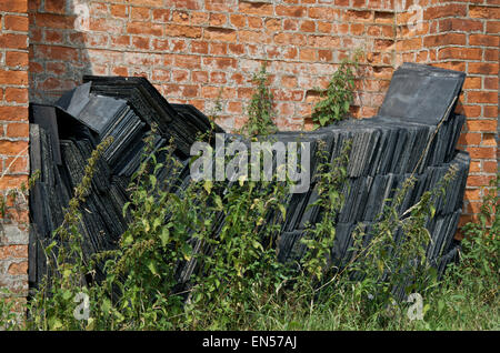 Schiefer Ziegel gestapelt gegen eine Mauer geborgen Stockfoto