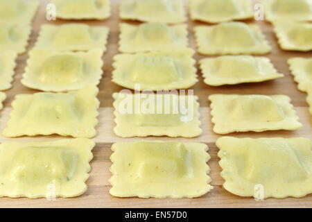 Ravioli in einer Reihe auf einem Holzbrett angeordnet Stockfoto