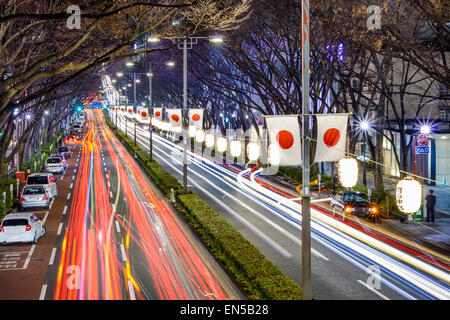Harajuku, Tokyo, Japan Verkehrsströme unter japanischen Fahnen in der Nacht. Stockfoto