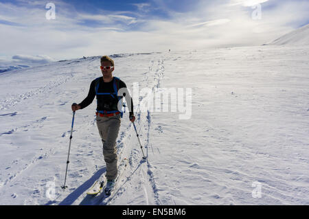 Männlichen Skifahrer in Silhouette Ski Langlauf auf Rornefjellet Berg, Lyngen Alpen (Lyngsalpene) Troms Grafschaft, Norwegen bereisen. Stockfoto