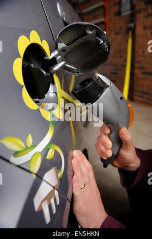 Einstecken eines Elektroautos zu Hause in einer Garage UK Stockfoto