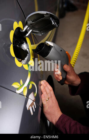 Einstecken eines Elektroautos zu Hause in einer Garage UK Stockfoto