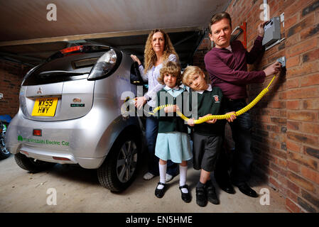 Betriebene Elektroauto in einem Einfamilienhaus in einer Garage UK einstecken Stockfoto