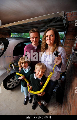 Betriebene Elektroauto in einem Einfamilienhaus in einer Garage UK einstecken Stockfoto