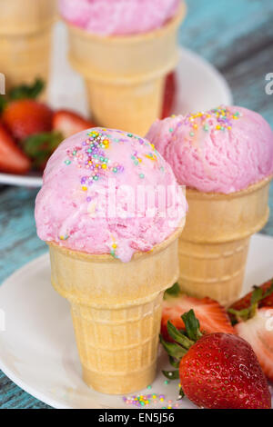Erdbeereis mit Streuseln Waffel-Cups gegen Holz Vintage-Hintergrund Stockfoto