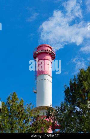 Einen einzigen rot-weiß gestreiften Rauch Schornstein mit Rauch in einem blauen Himmel bläst. Stockfoto