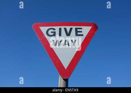 Geben Weg Straßenschild vor einem blauen Hintergrund UK Stockfoto