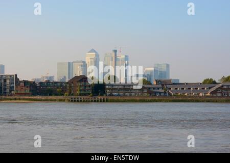 Moderne Wolkenkratzer Gebäude Docklands in London, England. Themse und Häuser im Vordergrund. Neblig und verschwommen Stockfoto