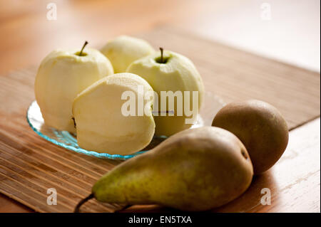 Geschälte Äpfel und Birnen auf Bambusmatte Stockfoto