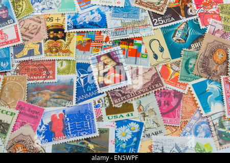 Stempel-Collage aus abgestempelte Briefmarken aus Ländern der ganzen Welt.  Hell leuchtende Farben für den Hintergrund Stockfoto