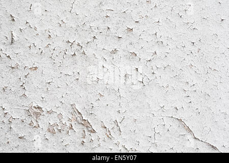 Ein Fragment der alten Mauer gemalt mit weißer Farbe, die im Laufe der Zeit geknackt. Peeling Paint Hintergrund. Stockfoto