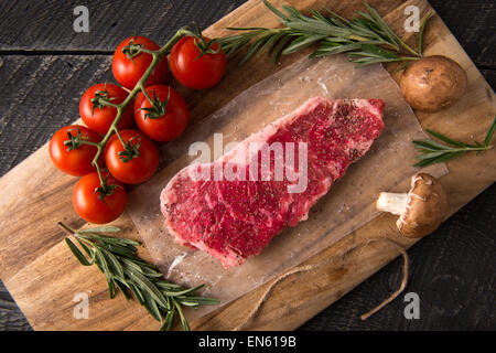 Serie: Grillen Strip Loin Steak in Gusseisen Pfanne: Zutaten enthalten, Stapel, Pilze, Tomaten und Rosmarin auf Schnitt Stockfoto