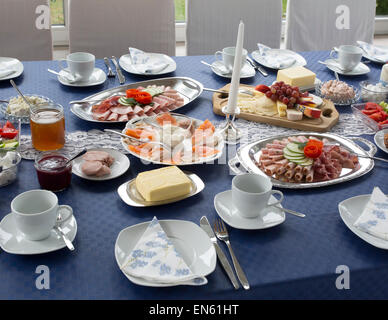 Frühstückstisch mit Platten mit Aufschnitt, Gemüse und andere Köstlichkeiten in Deutschland Stockfoto