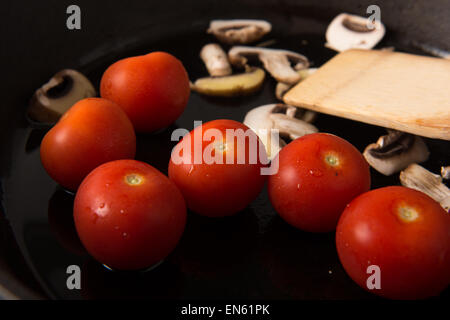 Serie: Grillen Strip Loin Steak in Gusseisen Pfanne: Zutaten, die in Scheiben geschnittenen Champignons und Tomaten zuerst vorbereitet Stockfoto