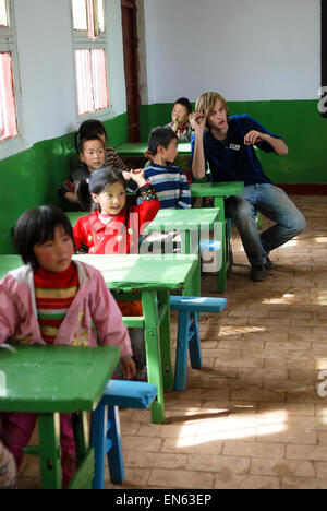 Ein Engländer hilft beim Unterrichten von Kindern an einer Schule in China. Stockfoto