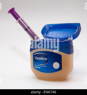 Wanne mit Vaseline Vaseline mit einer Spritze, isoliert auf weißem Hintergrund. Stockfoto