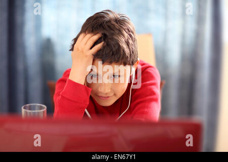 Kleiner Junge seine Hausaufgaben auf einem Computer - mit geringen Schärfentiefe Stockfoto