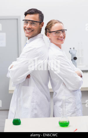 Lächelnde Wissenschaftler stehen Rücken an Rücken Stockfoto