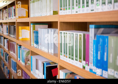 Bände Bücher im Bücherregal in Bibliothek Stockfoto