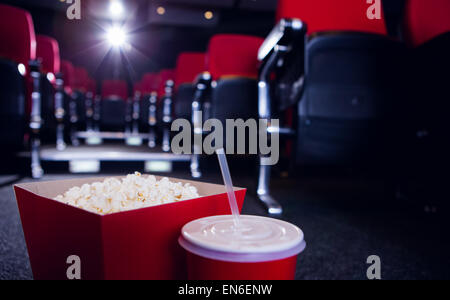 Leere Sitzreihen rot mit Popcorn und Getränken auf dem Boden Stockfoto