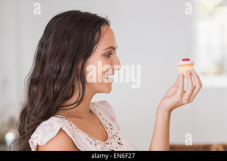 Schöne Brünette mit Mini cupcake Stockfoto