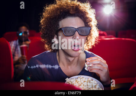 Junger Mann einen 3d Film und Essen popcorn Stockfoto