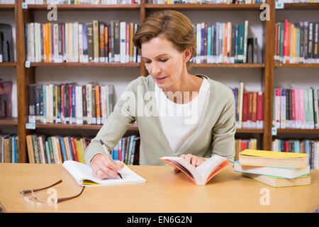 Lehrer schreiben auf Merkzettel in Bibliothek Stockfoto