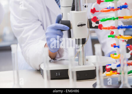 Wissenschaftler analysieren Petrischale mit dem Mikroskop Stockfoto