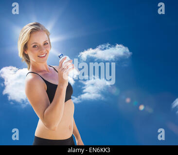 Das zusammengesetzte Bild von Fit blond Trinkwasser Stockfoto