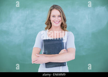 Lächelnd Lehrer halten Notebook vor Tafel Stockfoto