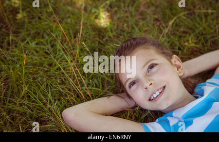 Niedliche kleine Mädchen auf dem Rasen liegend Stockfoto